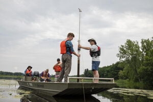 Five people on a boat with a sediment core