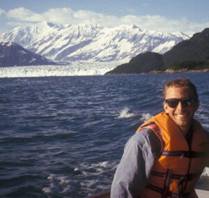 David Barclay on a boat with Hubbard Glacier in the background