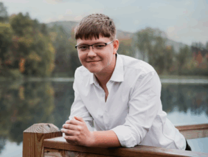 Daniel smiling at camera with water in background.