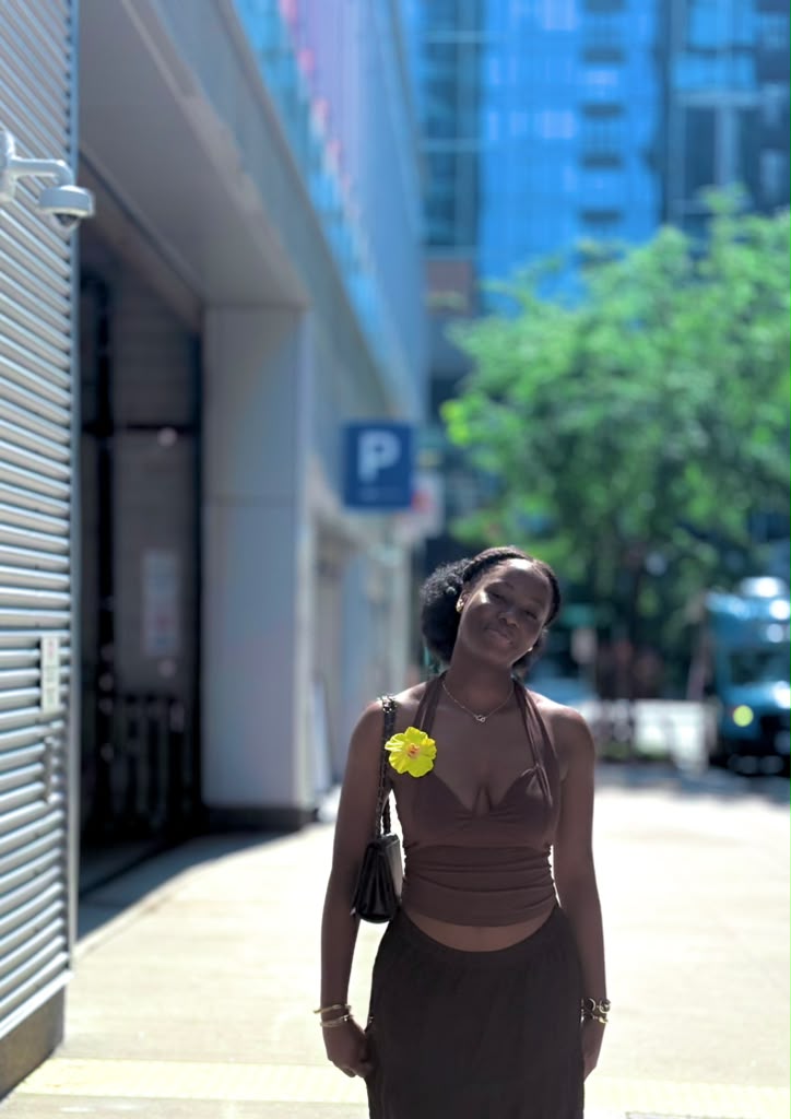Hawa standing on sidewalk smiling.